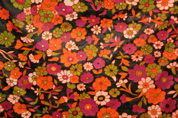 Detail of Sam Hamilton's artwork "GURL PWR," featuring a vintage orange, green, and pink floral pattern. MFA Thesis Exhibition 2023