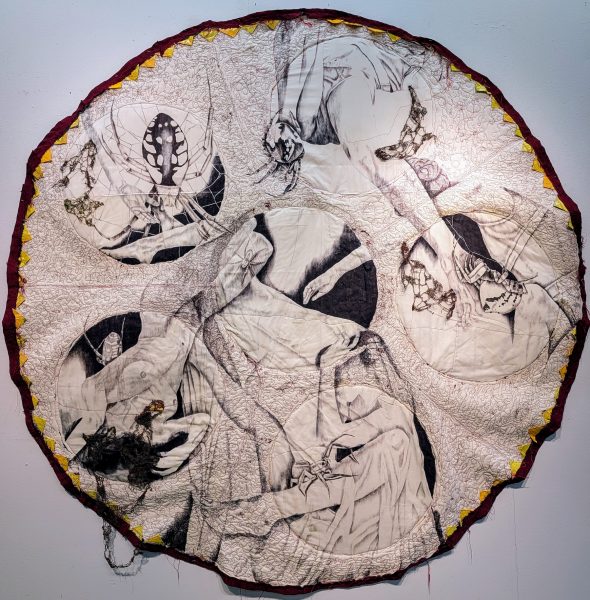 A circle textile piece of art with female nude images and a spider