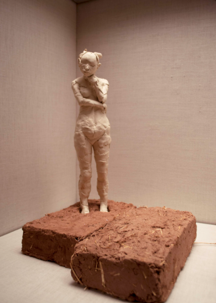 A ceramic 3D image of a woman standing on adobe bricks