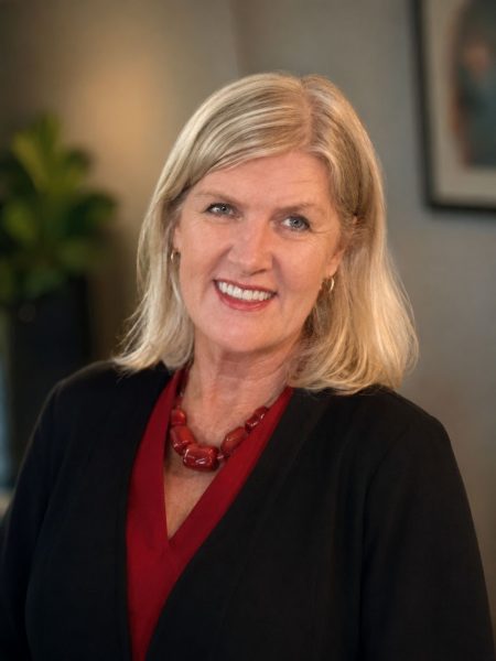 A woman dressed professionally in a red blouse and black jacket
