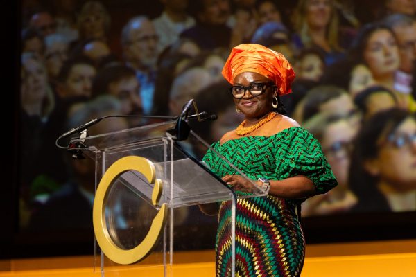 Iroro Tanshi receiving the Goldman Environmental Prize. A woman with colorful clothes at a podium.